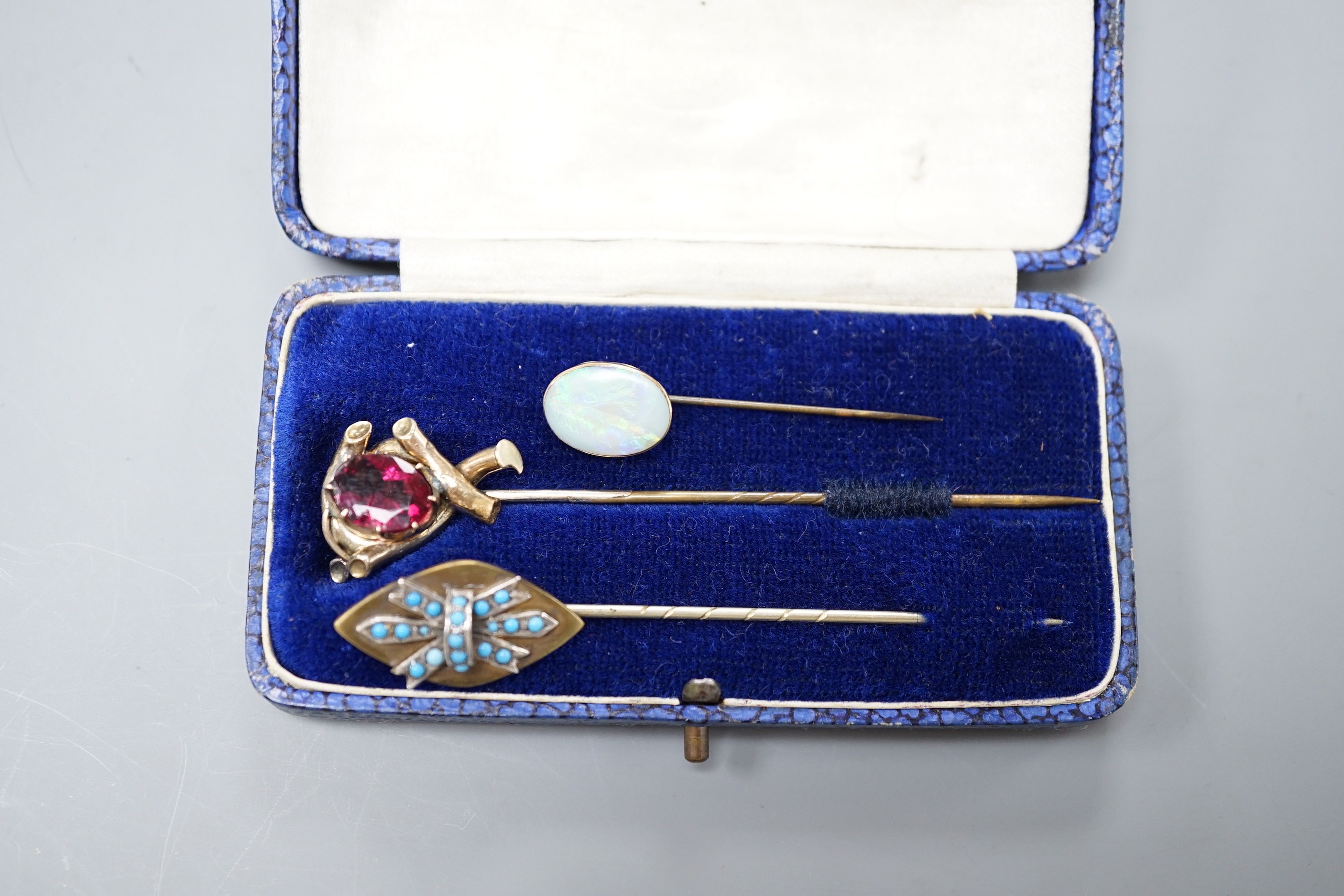 Three various base metal stick pins, one set with white opal doublet?, 45mm.